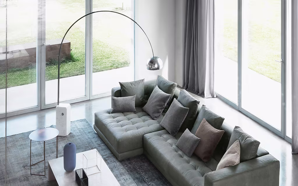 Arco floor lamp by Flos beside a sofa