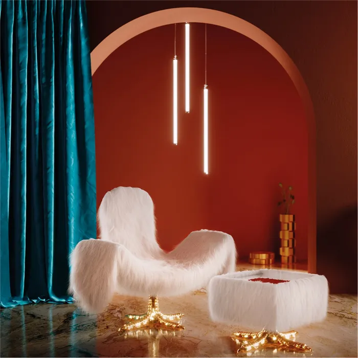 “Cocky Armchair by Driade – versatile seating with adjustable armrests, backrest, and headrest, upholstered in white faux fur with a gold base, offering customizable comfort and bold design by Sfera Ebbasta.”
