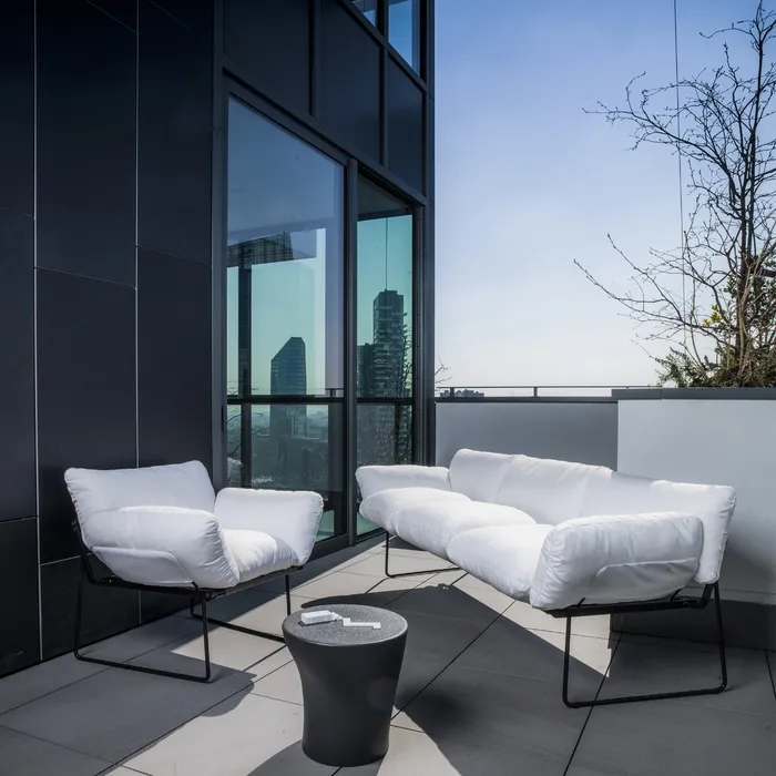 “Elisa Armchair by Driade – elegant lounge chair with soft grey upholstery and minimalist black-brown steel frame, designed by Enzo Mari, enhancing modern living spaces with refined design.”
