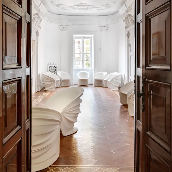 “Side profile of Modesty Veiled Armchair by Driade – elegant armchair featuring soft, draped lines and a smooth seating interior, designed by Italo Rota.”