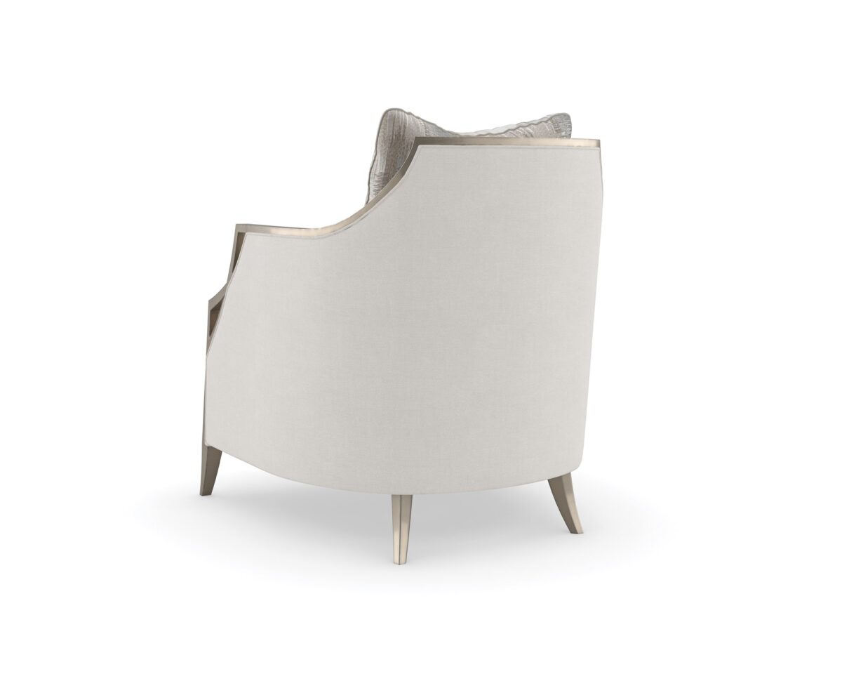 The Caracole X Factor Sofa, a modern classic upholstered in a herringbone performance fabric, featuring a wood-trimmed silhouette with a carved crisscross pattern, gently sloping arms, splayed legs in a metallic Charcoal Leaf finish, and feather-down toss pillows.