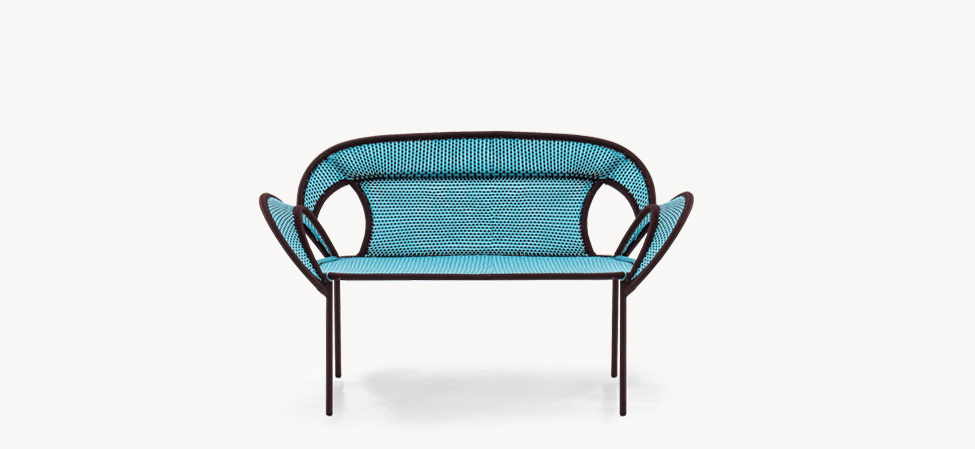 Banjooli by Moroso armchair with multicolor patchwork fabric and rounded wooden legs in a bright living room