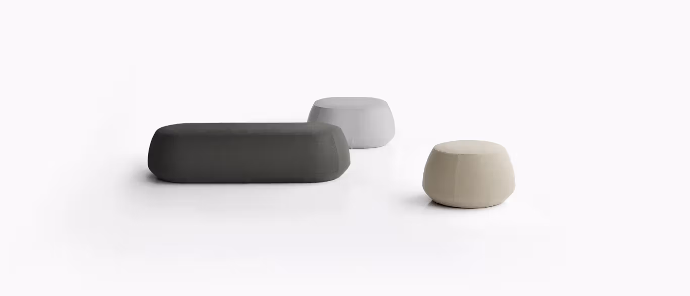 Ile Pouf by Bensen in soft gray fabric with rounded edges and plush cushioning on a hardwood floor