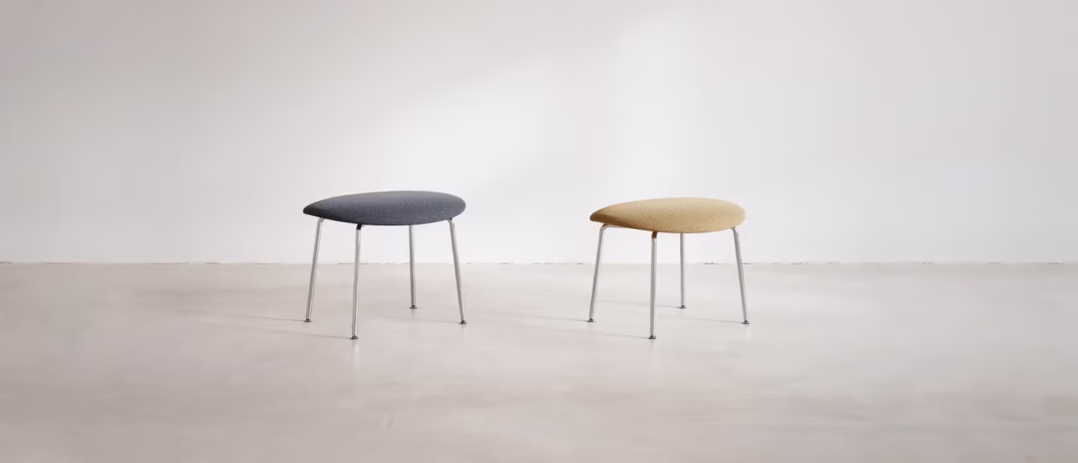 Otto by Bensen ottoman in charcoal fabric with soft edges and low profile on a light wood floor
