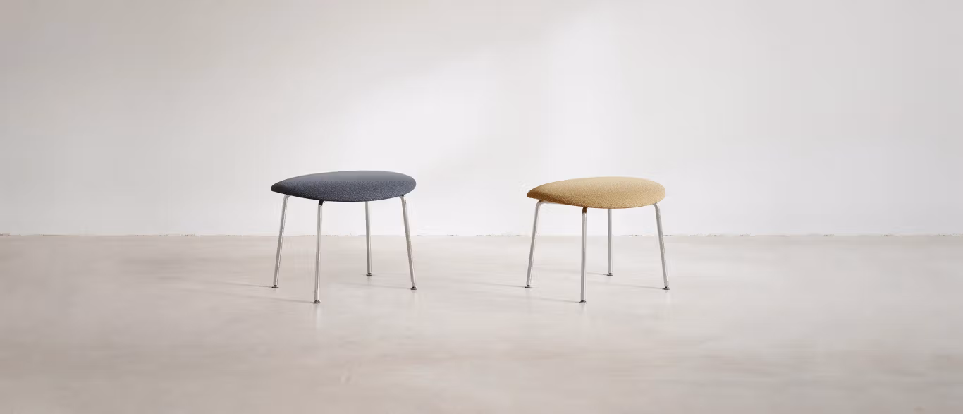 Otto by Bensen ottoman in charcoal fabric with soft edges and low profile on a light wood floor