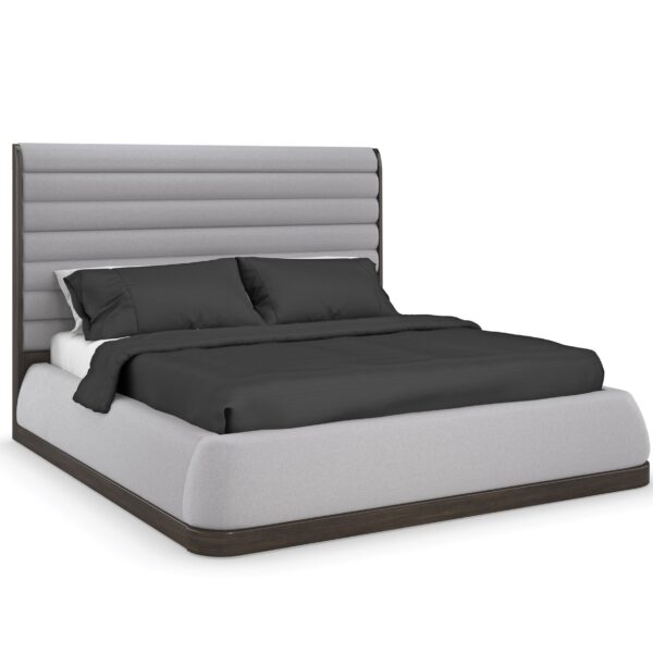 Caracole La Moda Upholstered Panel Bed featuring a channel-tufted headboard and upholstered footboard and side rails in pebble gray billiard cloth, with Sepia-finished frame and platform base, and optional wing panels extending the headboard on either side.