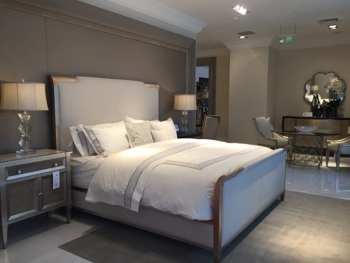 Caracole Nite In Shining Armor King Bed featuring an elegant wood frame in an aged leaf finish reminiscent of old silver, with fabric insets showcasing a small ribbed weave in off-white and light oyster coloration.