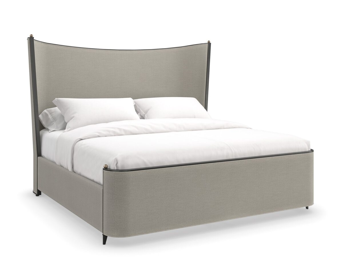 Caracole Provence King Bed featuring a fully upholstered frame in warm gray fabric resembling Belgian linen, complemented by an exposed wood frame and tapered metal legs in Craftsman Bronze Paint, accented with decorative brushed gold balls.