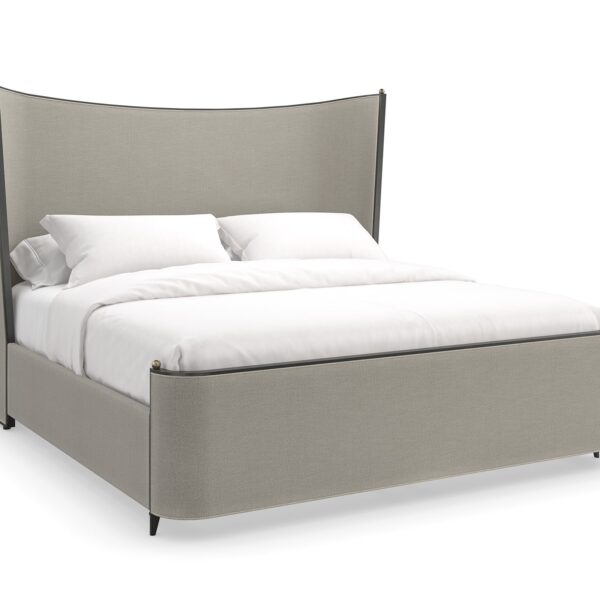 Caracole Provence King Bed featuring a fully upholstered frame in warm gray fabric resembling Belgian linen, complemented by an exposed wood frame and tapered metal legs in Craftsman Bronze Paint, accented with decorative brushed gold balls.