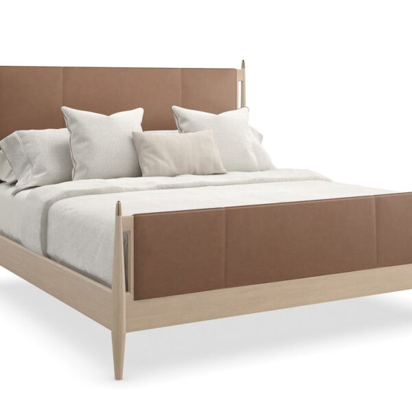 Caracole Rhythm King Bed featuring a luxurious camel-colored leather upholstered headboard and footboard, complemented by a Sun Drenched Oak wood frame with metal finials in Lucent Bronze finish, designed with clean, parsons-style lines.