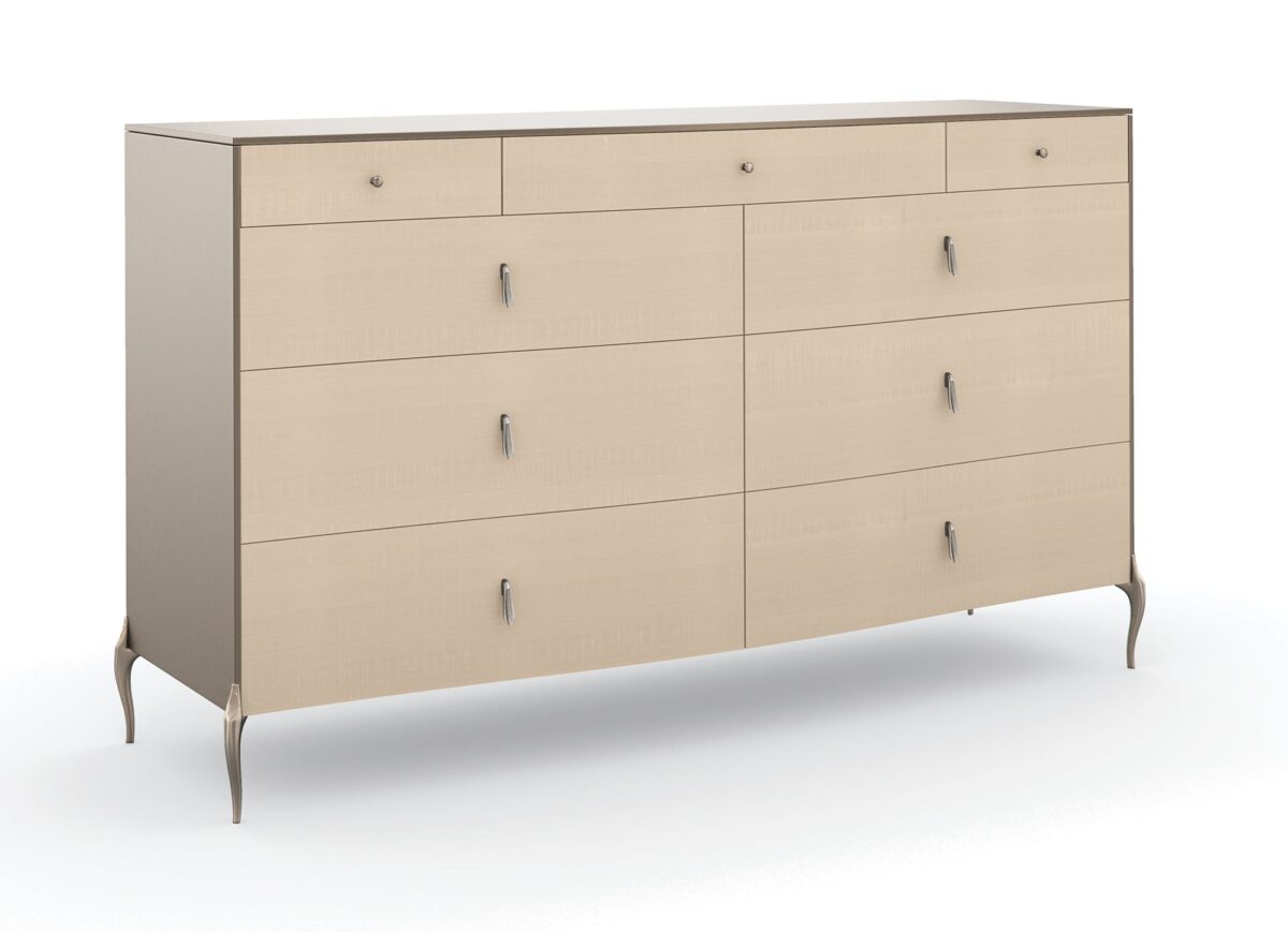 Dress to Impress Dresser by Caracole — a 62″ wide nine‑drawer dresser in soft‑silver painted Asian hardwood case, with vanilla‑cream figured‑sycamore drawer fronts, elongated Art‑Deco style metal pulls, a gently curved top, ornate silver‑toned legs, and two felt‑lined top drawers.