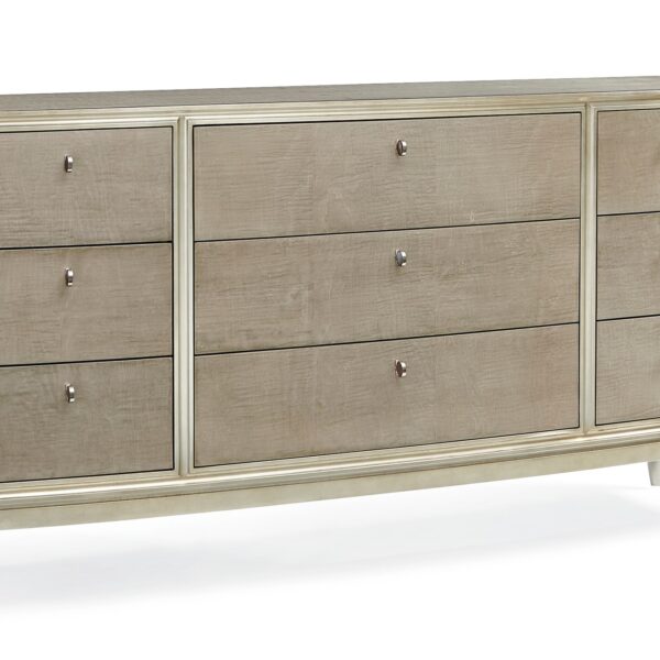 Made To Shine Dresser by Caracole — a 72″ wide nine-drawer dresser in Moonlit Sand–finished curly maple, accented with Soft Silver Leaf trim on the frame and base, topped by lightly brushed chrome metal ferrules on tapered legs, featuring antique silver knobs with black mother-of-pearl centers and soft-close undermount drawer guides.