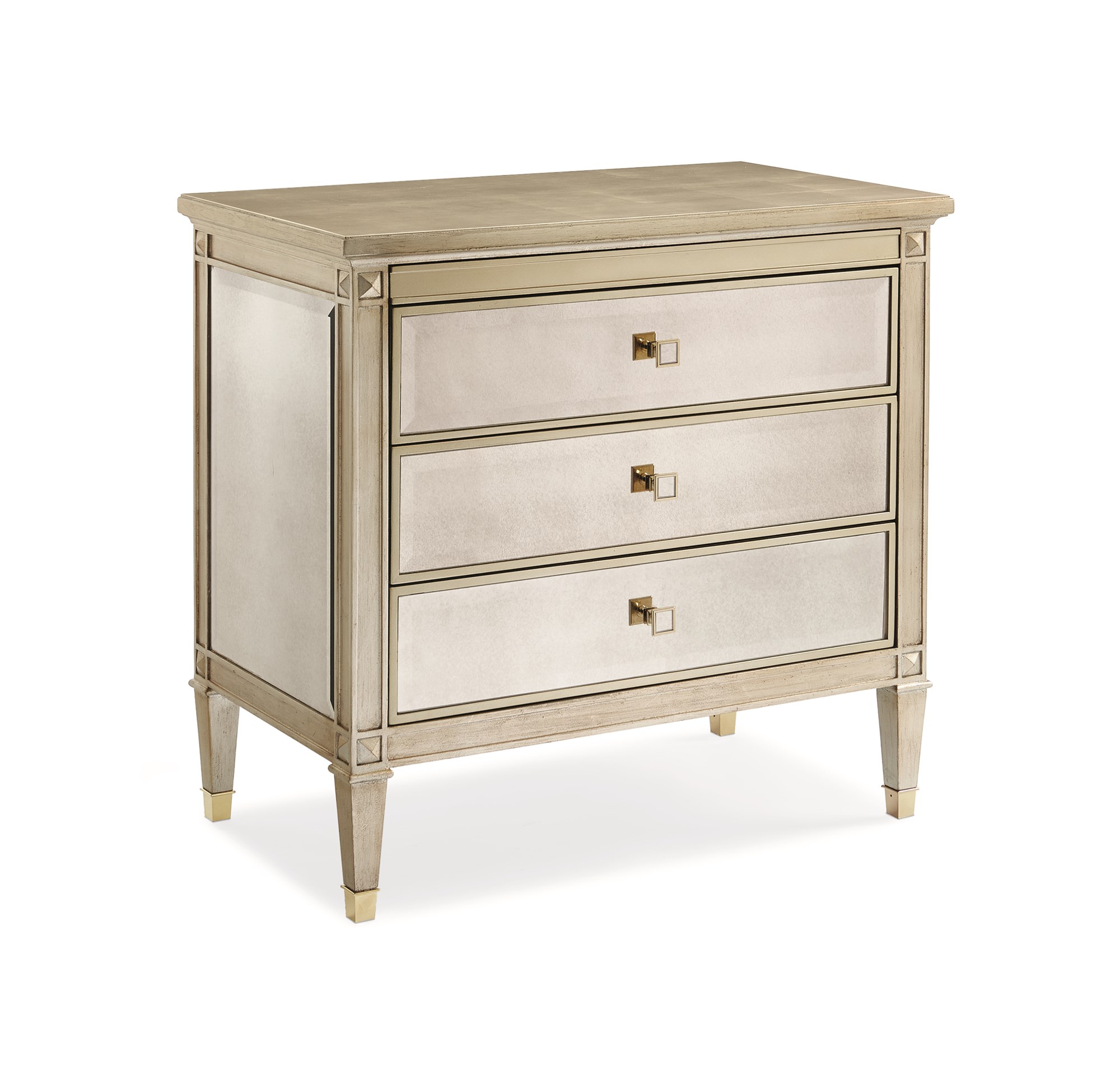 A Classic Beauty by Caracole — a 32″ wide Italian-inspired nightstand with three soft-close drawers featuring beveled antique-mirror fronts framed in Auric silver leaf finish, square mirrored-inset pulls, carved tapered feet with metal ferrules, and a sparkling gold-painted interior shelf.