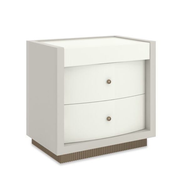 Calais Nightstand by Caracole — a 28″‑wide nightstand featuring a square case in Rockport Burnished Adobe finish with a top in Almond Milk. It includes two bow-front drawers with soft-close undermount guides, small ball-pulls in Brushed Gold, and a reeded base finished in Antique Bronze Leaf. The drawer interiors are painted Almond Milk, and the piece offers hidden openings for power cords.