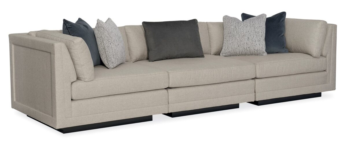 Caracole Fusion 3 Piece Sectional featuring a neutral, menswear-inspired textured tweed pattern, recessed Simply Black wood plinth base, cut-out frame detailing, and contrasting accent pillows in gunmetal velvet and black-and-white herringbone stitch.