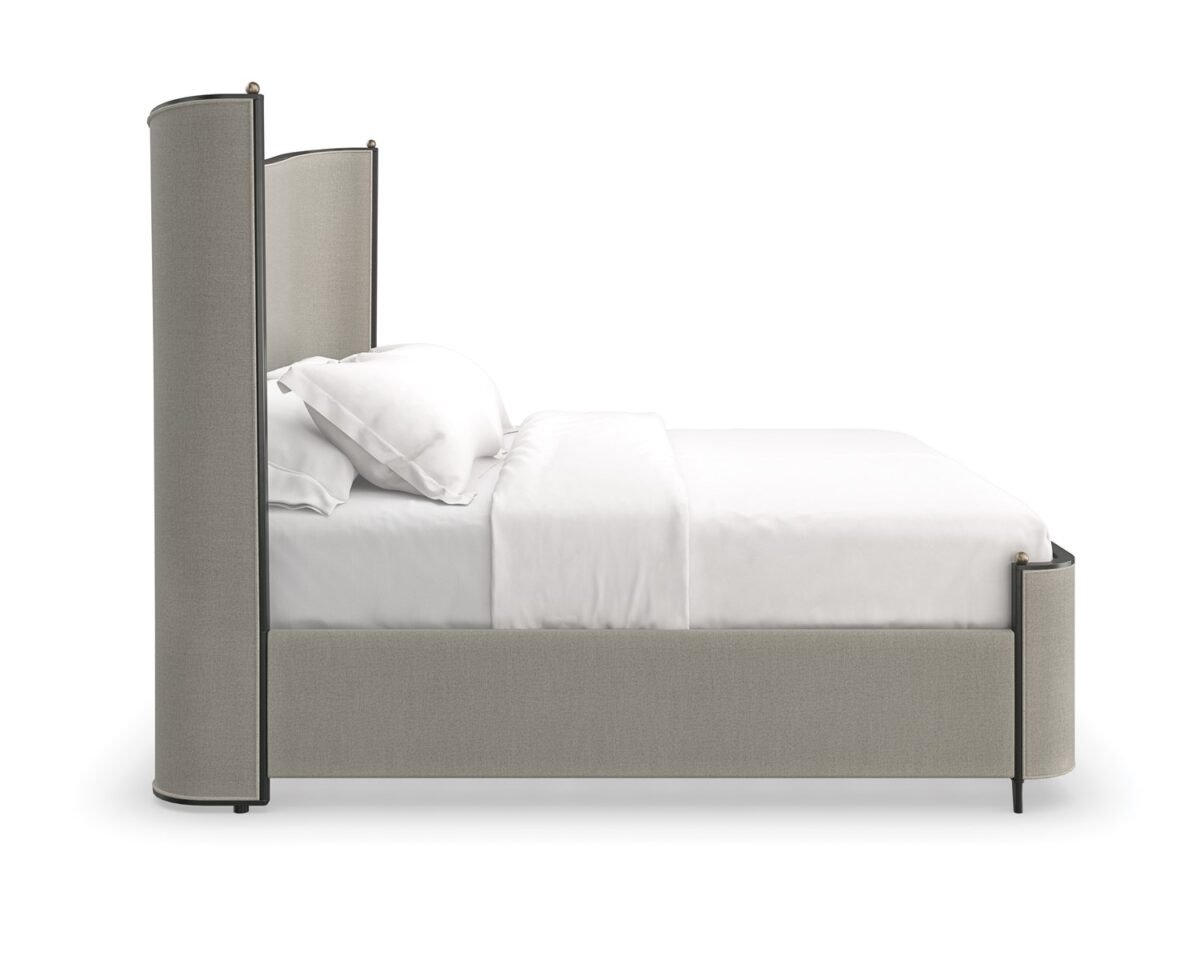 Caracole Provence King Bed featuring a fully upholstered frame in warm gray fabric resembling Belgian linen, complemented by an exposed wood frame and tapered metal legs in Craftsman Bronze Paint, accented with decorative brushed gold balls.