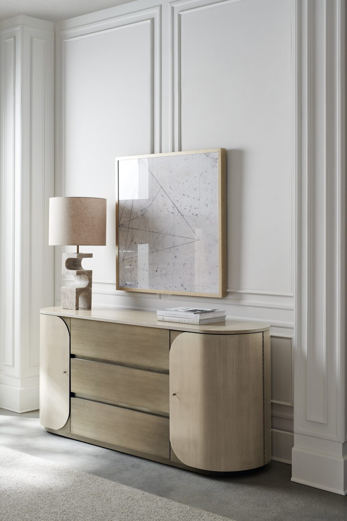 Vita Duo Dresser by Caracole—a sleek oval dresser with dual-tone Smoked Stainless Steel finish, featuring two curved doors with subtle wood grain and three central drawers for a modern minimalist aesthetic.