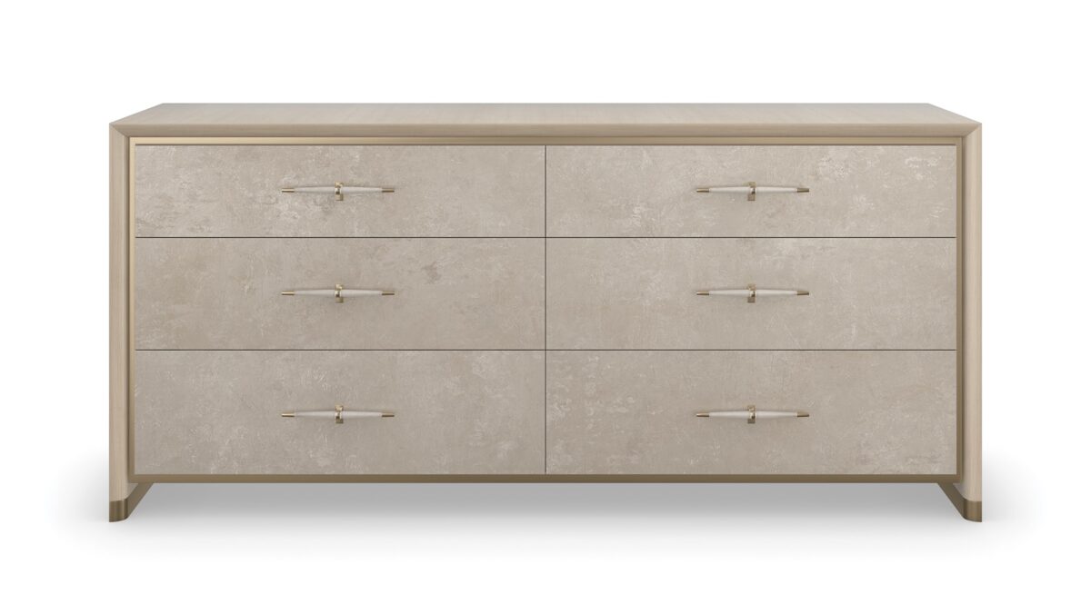 Hang Up Dresser by Caracole — a 70‑inch wide classic dresser with six drawers featuring metallic leaf-finish fronts that shimmer like frosted glass, set in a Dry Martini-finished hardwood frame with recessed metal trim, tapered faux‑leather-wrapped pulls in brushed gold and nickel, soft‑close drawers, and linen-painted interior with top drawer dividers and a removable jewelry tray.