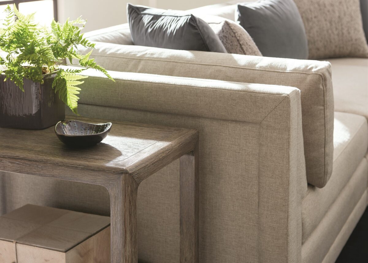 Caracole Fusion 3 Piece Sectional featuring a neutral, menswear-inspired textured tweed pattern, recessed Simply Black wood plinth base, cut-out frame detailing, and contrasting accent pillows in gunmetal velvet and black-and-white herringbone stitch.