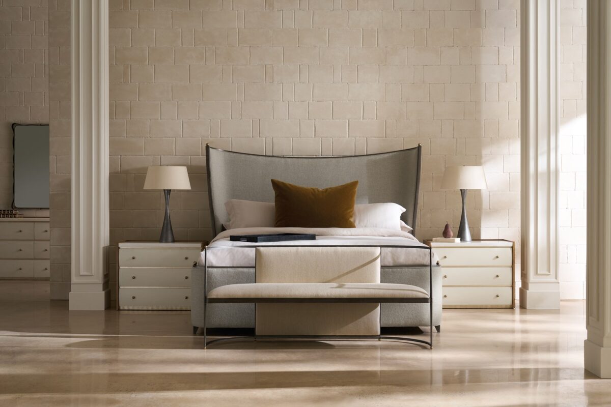 Caracole Provence King Bed featuring a fully upholstered frame in warm gray fabric resembling Belgian linen, complemented by an exposed wood frame and tapered metal legs in Craftsman Bronze Paint, accented with decorative brushed gold balls.