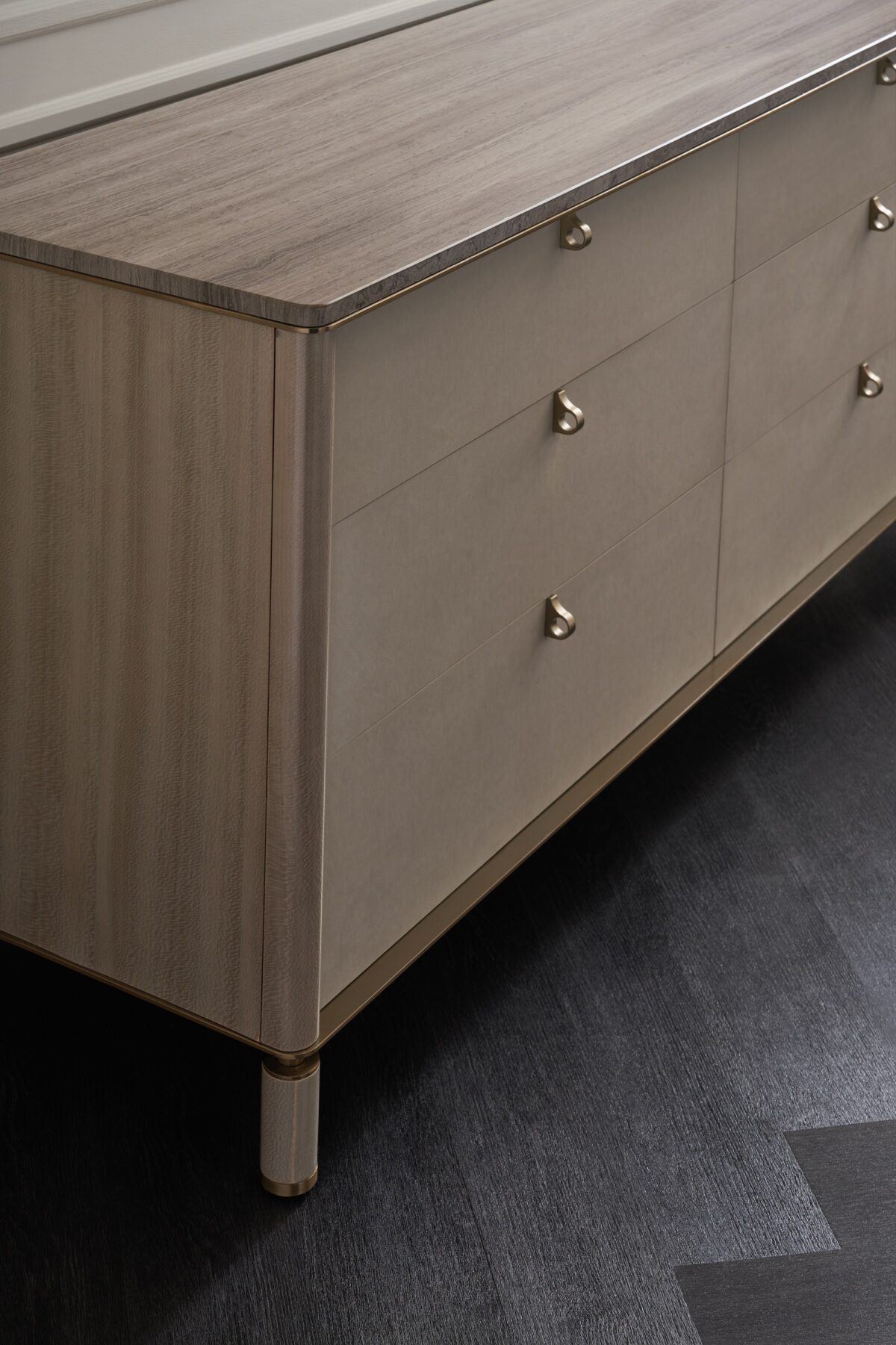 Modern dresser with a travertine stone top, light-toned drawers, and a bronze metallic base, BALANCE Dresser by Caracole.