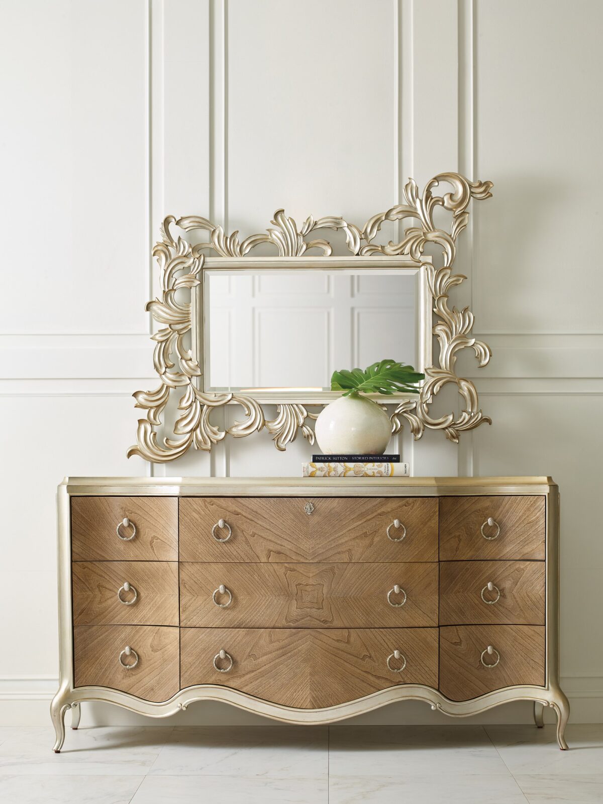 Fontainebleau triple dresser by Caracole — a serpentine‑front dresser with nine drawers crafted from Cendre-finished flat-cut walnut and trimmed in Champagne Mist, featuring carved cabriole legs, custom ring pulls with vintage cameo details, and a softly scalloped silhouette.