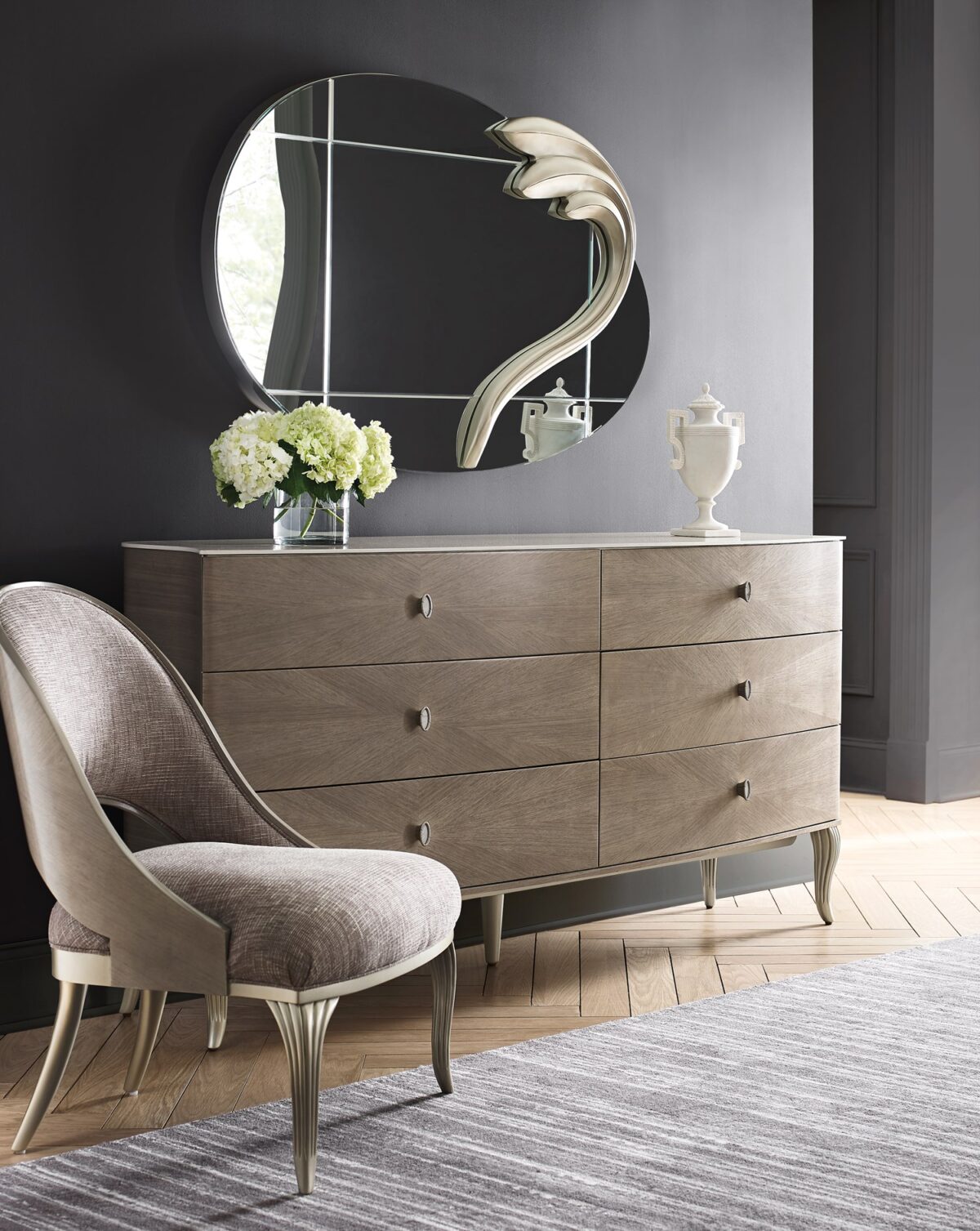 LILLIAN double dresser by Caracole — a 75″ wide glam dresser with six soft‑close drawers featuring radiating sunburst-patterned koto veneer in Stone Manor finish, accented by Art Deco ceramic-inset ring pulls, carved cabriole legs in shimmering Soft Radiance paint, and a contrasting Ivory Wash top.
