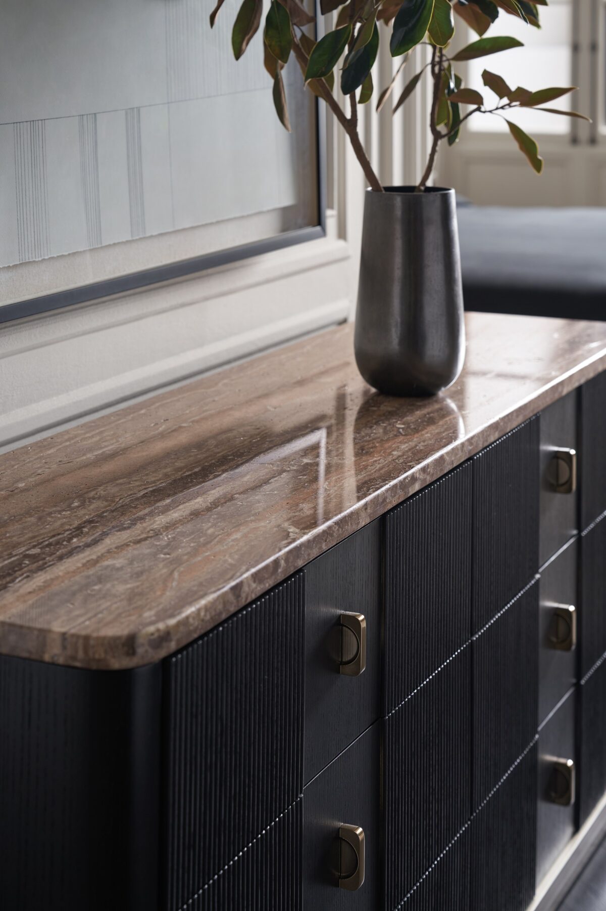 Rhythm Dresser by Caracole — a 69½″ wide six-drawer dresser featuring tactile reeded drawer fronts in Sun Drenched Oak finish, topped with creamy Travertine stone and set on a low neutral‑metal plinth, with rounded corners, bronze bar pulls, and soft‑close undermount guides.
