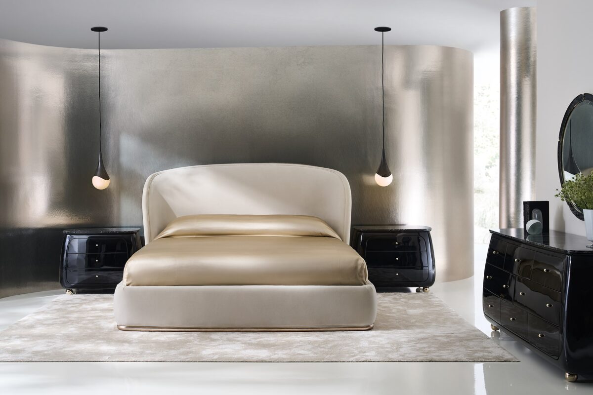 Cabochon Nightstand by Caracole — a 34″‑wide sculptural nightstand with a rounded Piano Black resin frame, featuring a flat Tree Black stone top with natural black and grey veining; three curved drawers with soft-close undermount guides and Piano Black interiors; Whisper of Gold spherical metal knobs and matching ball feet complete the luxurious design.