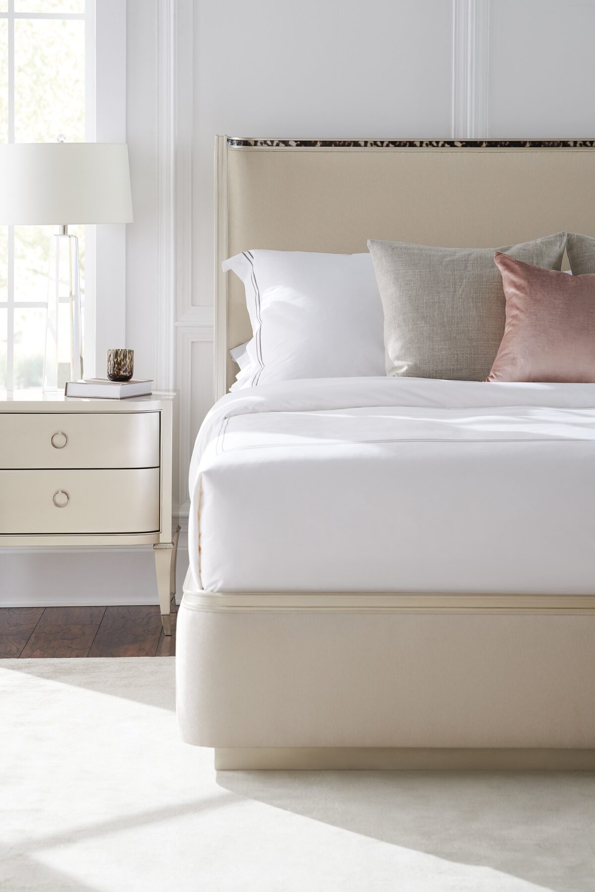 Caracole Dream Big California King Bed featuring a gently curving headboard with acrylic tortoise shell-inspired inlay, upholstered footboard and side rails in performance fabric, and a contemporary plinth base in Soft Silver Paint.