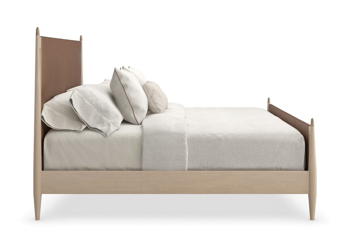 Caracole Rhythm King Bed featuring a luxurious camel-colored leather upholstered headboard and footboard, complemented by a Sun Drenched Oak wood frame with metal finials in Lucent Bronze finish, designed with clean, parsons-style lines.