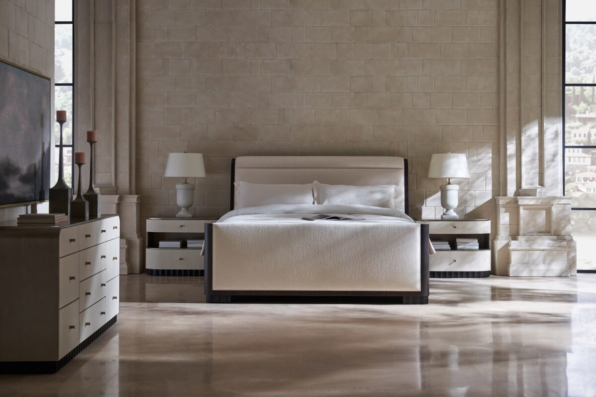 Caracole Slow Wave King Bed featuring a canted upholstered headboard and clean-lined footboard in faux slub silk, complemented by an Otter-finished footboard and side rails, and fluted Dark Chocolate legs.