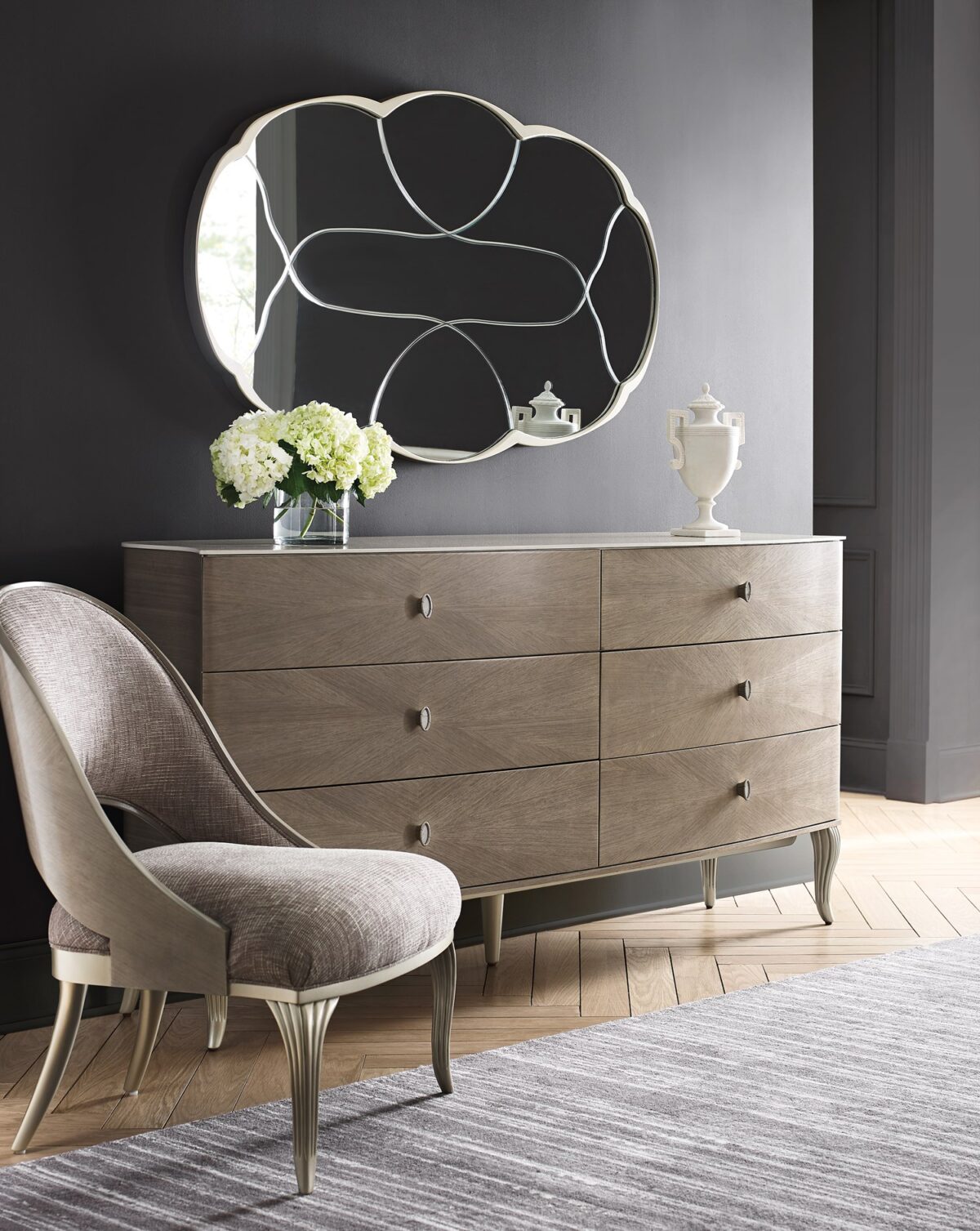 LILLIAN double dresser by Caracole — a 75″ wide glam dresser with six soft‑close drawers featuring radiating sunburst-patterned koto veneer in Stone Manor finish, accented by Art Deco ceramic-inset ring pulls, carved cabriole legs in shimmering Soft Radiance paint, and a contrasting Ivory Wash top.