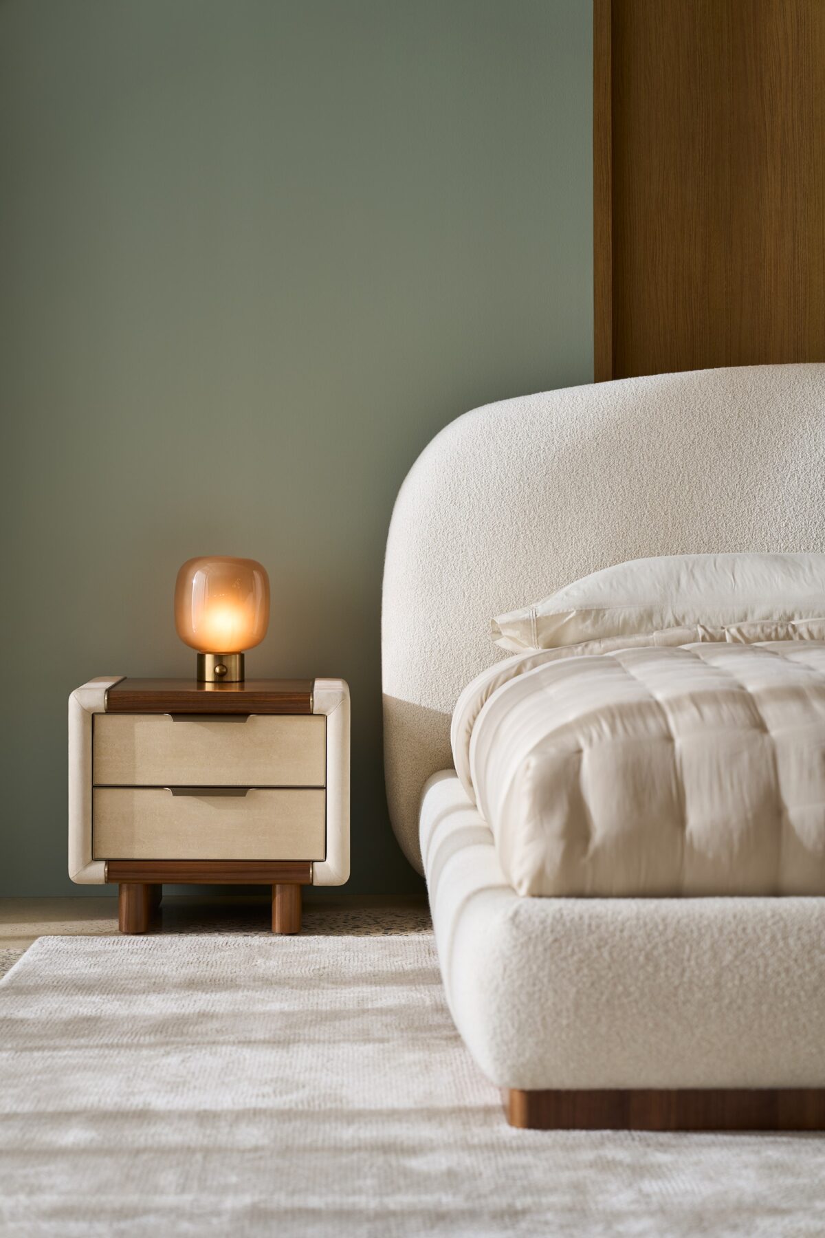Botero Small Nightstand by Caracole — a compact 24″‑wide bedside chest with bullnose-rounded edges, featuring a Retro Walnut top and legs, a single smoked‑Birdseye Maple drawer front with swirling grain, stone‑tone micro‑suede–wrapped sides, slim Brushed‑Gold metal trim, integrated curved pull, and a soft‑close drawer with UV‑Linen–painted interior.
