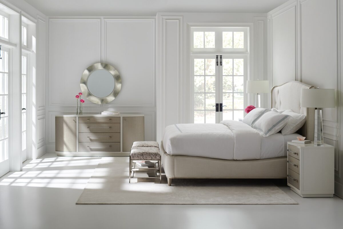 Moment of Clarity vanity by Caracole — a 48″‑wide console with a Soft Silver Leaf finish, featuring a lift-top with an interior mirror, silkscreen detailing on the top, and a front apron that drops down to provide a flat working surface. It stands on tapered round acrylic legs with ferrules in plated Whisper of Gold, and the interior is finished in Blanc.