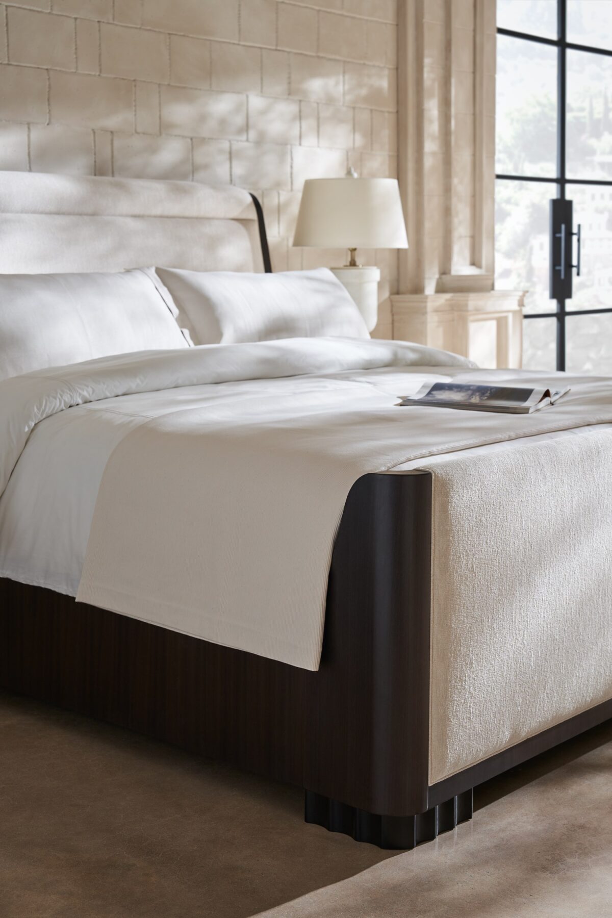 Caracole Slow Wave King Bed featuring a canted upholstered headboard and clean-lined footboard in faux slub silk, complemented by an Otter-finished footboard and side rails, and fluted Dark Chocolate legs.