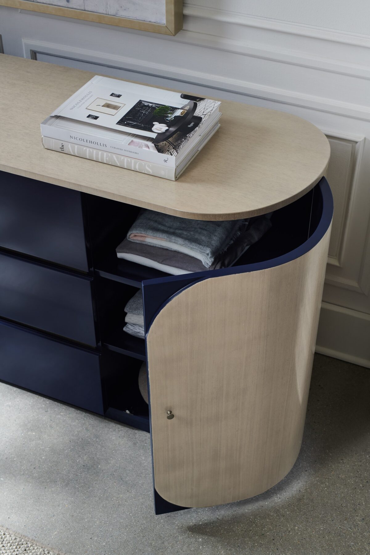Da Vita Dresser by Caracole with three center drawers in Prussian Blue and curved side doors in Thunder finish, featuring a soft oval silhouette and sleek modern design.