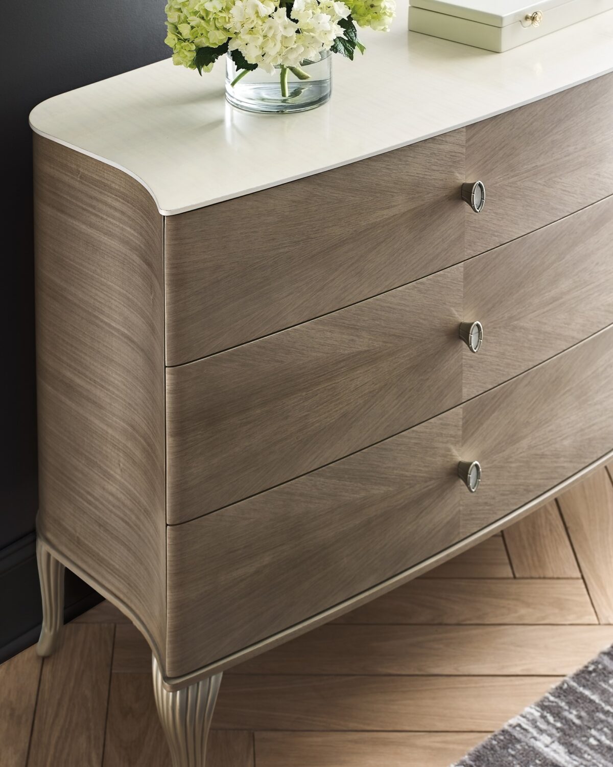 LILLIAN double dresser by Caracole — a 75″ wide glam dresser with six soft‑close drawers featuring radiating sunburst-patterned koto veneer in Stone Manor finish, accented by Art Deco ceramic-inset ring pulls, carved cabriole legs in shimmering Soft Radiance paint, and a contrasting Ivory Wash top.