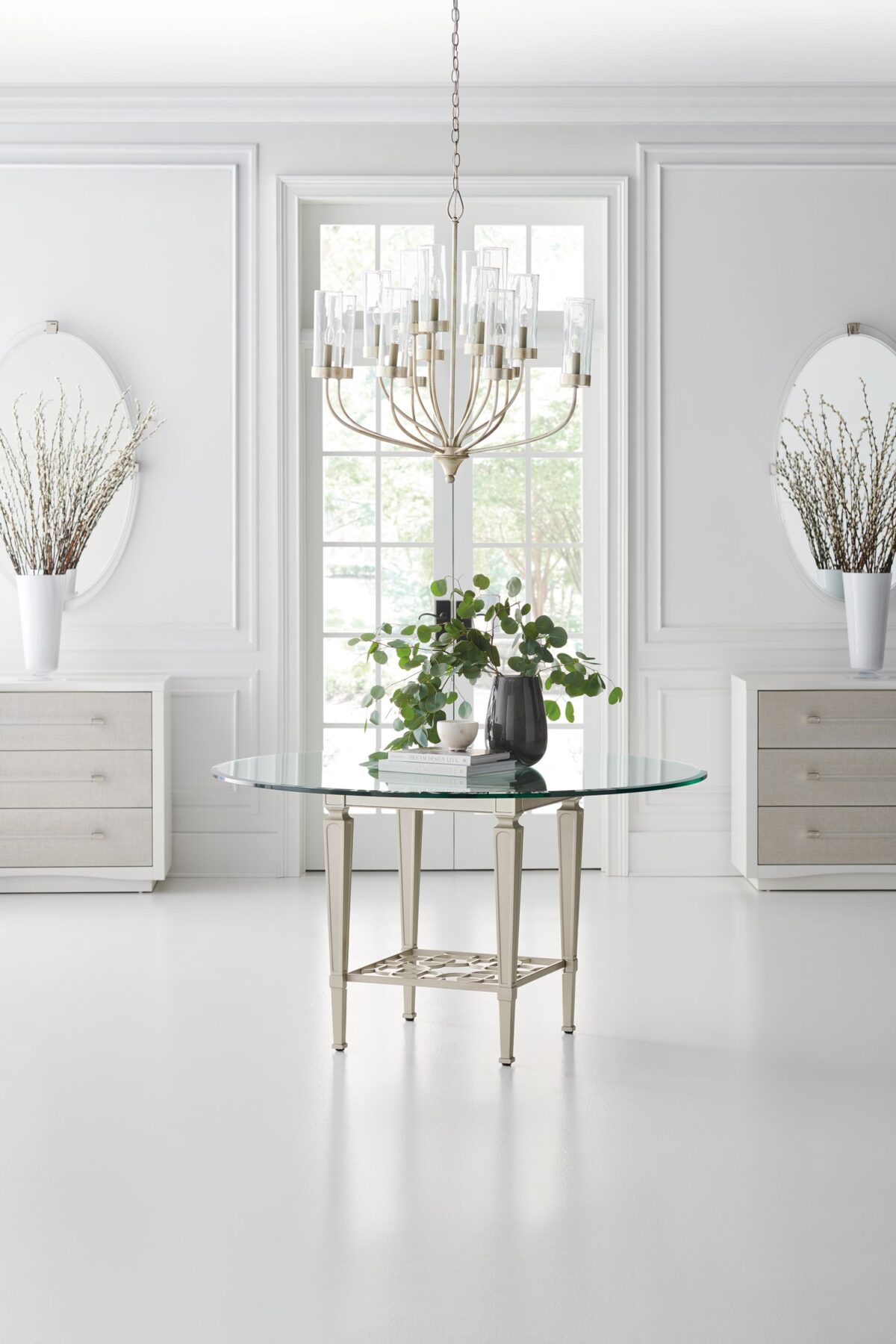 A Clear Touch chest by Caracole — a 38″‑wide three‑drawer chest in Pearly White textured finish, with sun‑kissed silver raffia-wrapped drawer fronts, clear acrylic rod pulls capped in satin nickel, undermount soft‑close guides, and painted pearly-white drawer interiors.