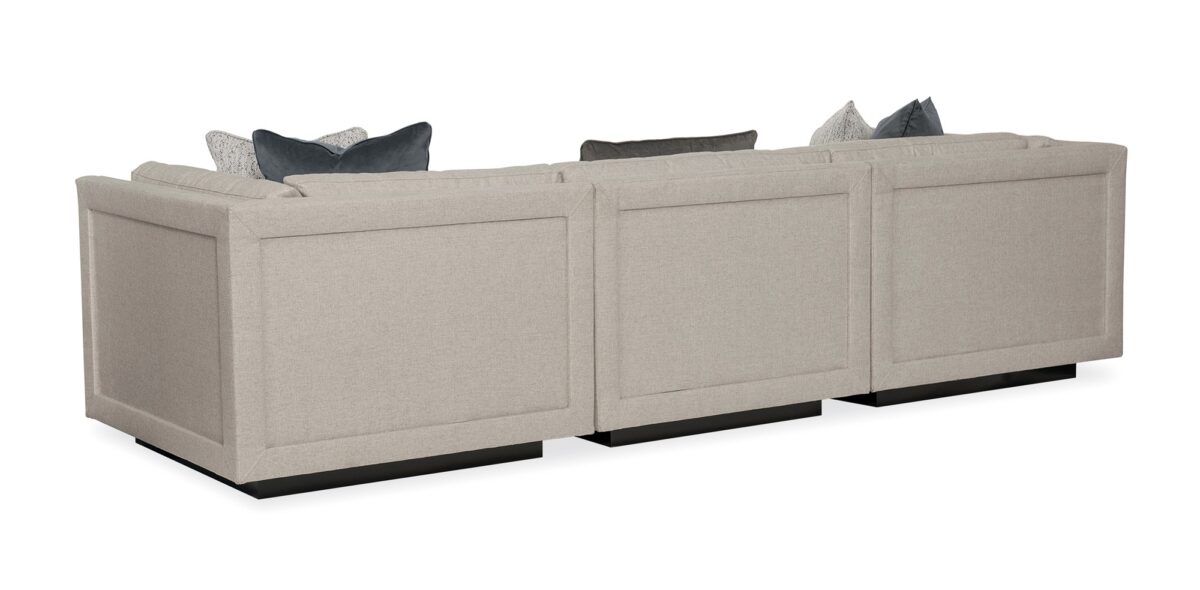 Caracole Fusion 3 Piece Sectional featuring a neutral, menswear-inspired textured tweed pattern, recessed Simply Black wood plinth base, cut-out frame detailing, and contrasting accent pillows in gunmetal velvet and black-and-white herringbone stitch.