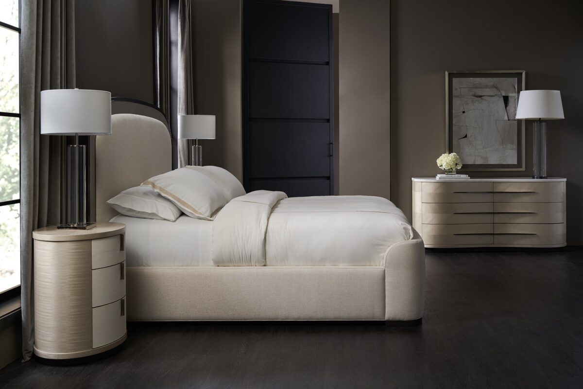 Roam Dresser by Caracole — a sleek 68″‑wide dresser in pearlescent Moonstone finish with six gently curved soft‑close drawers featuring horizontal Deep Bronze handles; chevron‑patterned Koto veneers flow organically across the fronts and end panels, topped with luxurious white Rhino marble and set atop a Seal‑Skin tone plinth base.