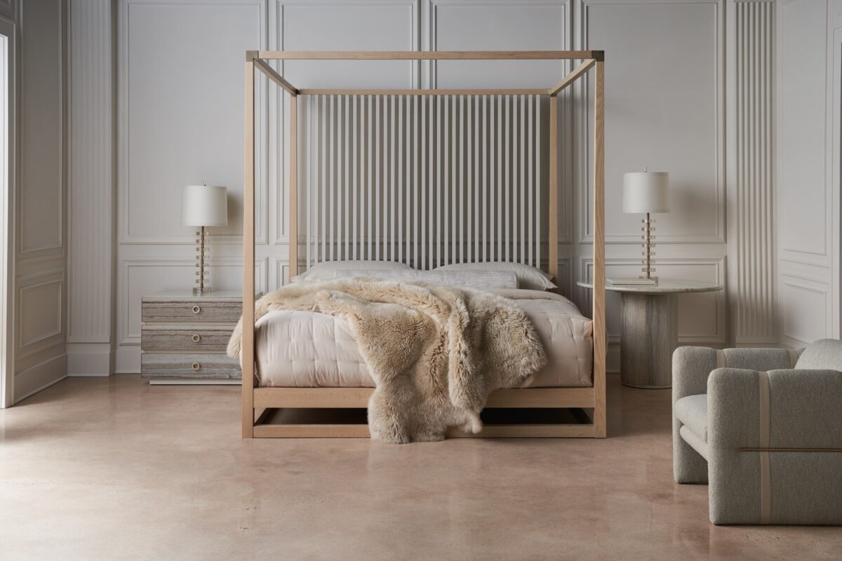 Bedrock Nightstand by Caracole — a 34″‑wide three‑drawer nightstand with polished gray sandstone fronts featuring subtle champagne‑gold trim and ring pulls, set in a creamy Almond Milk wood frame with a matching plinth base and soft‑close undermount drawer guides.