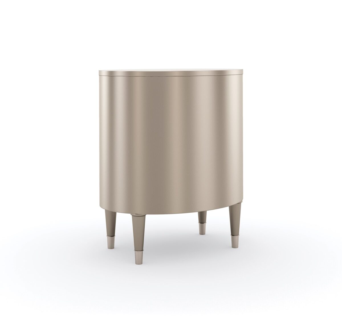 Bedside Beauty Nightstand by Caracole — a 24″-wide oval nightstand with three soft‑close drawers, finished in shimmering soft‑silver paint on Asian hardwood, topped with a softly curved top, accented by polished stainless‑steel ferrules on tapered legs, and elongated Art‑Deco pendant-style drawer pulls with faux-stone centers.
