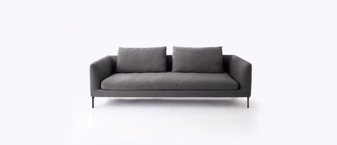 Delta Sectional by Bensen in light gray fabric with low profile, wide arms, and plush cushions in a modern living space