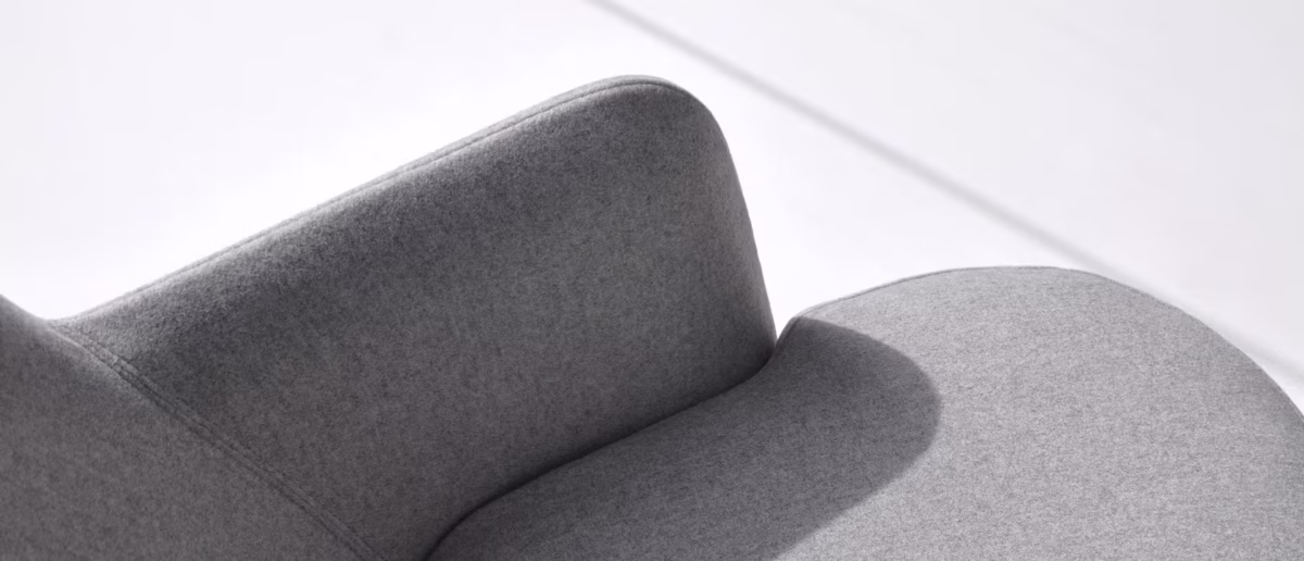 My Turn swivel lounge chair by Bensen, featuring a high wingback design and a sleek metal base that rotates 360°, offering both comfort and style.