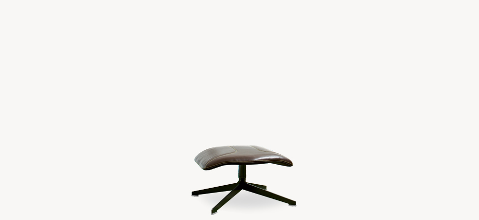 Take a Line For a Walk pouf in beige leather atop a black swiveling four-star base, set on a parquet floor.