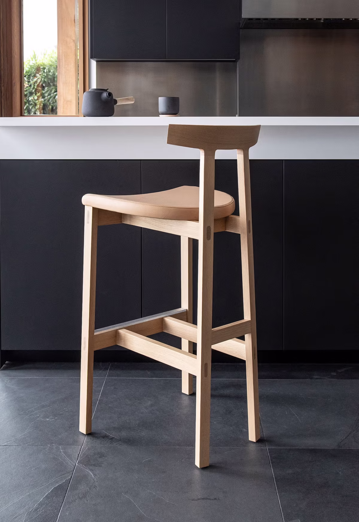 Contemporary TORII counter stool by Bensen, showcasing its sleek, understated design with a comfortable seat and slender, elegant legs.