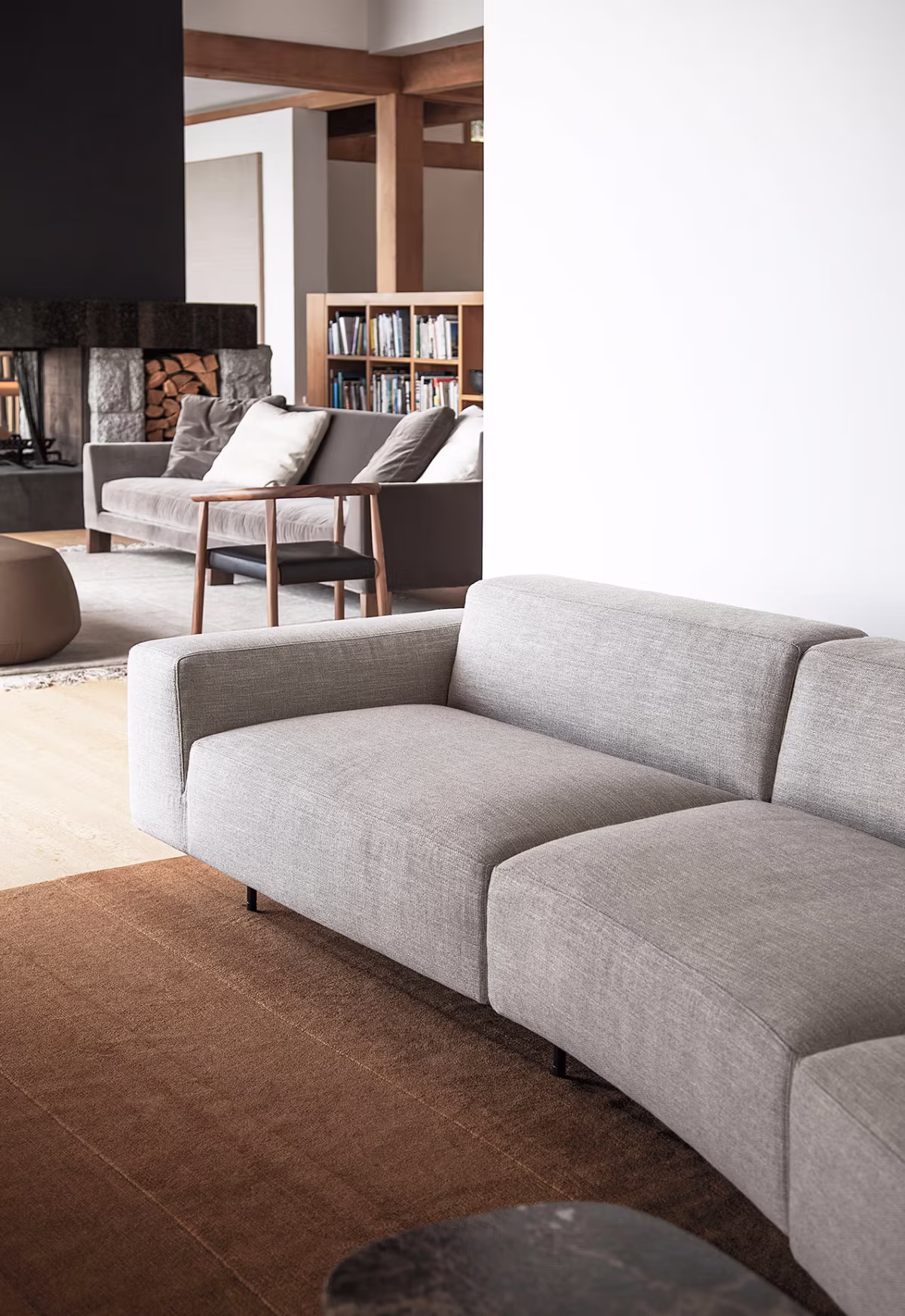 Spacious living area featuring Endless by Bensen in beige fabric with a large coffee table and floor-to-ceiling windows