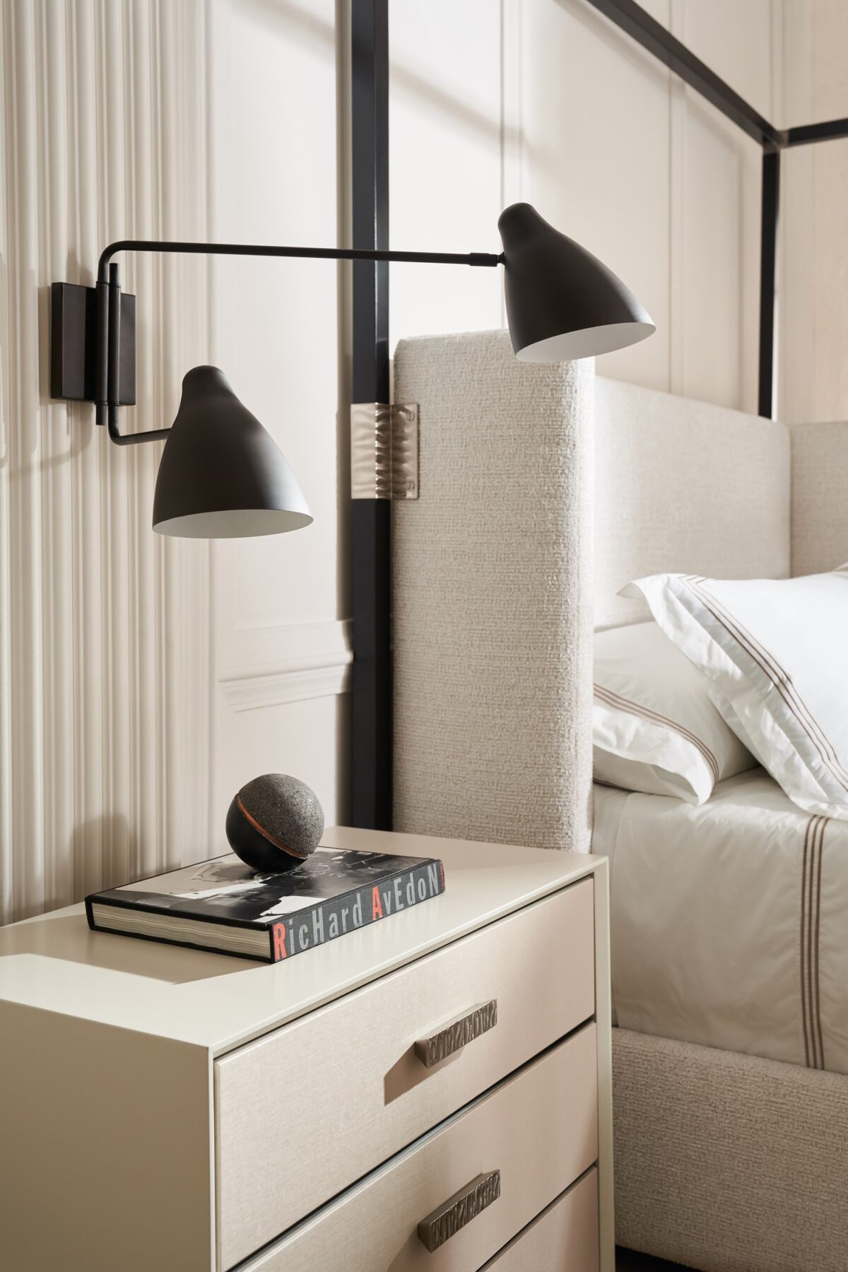 Caracole Shelter Me King Bed featuring a soft chenille upholstered headboard, footboard, and side rails, complemented by decorative buttons and a plinth base in Almost Black finish.
