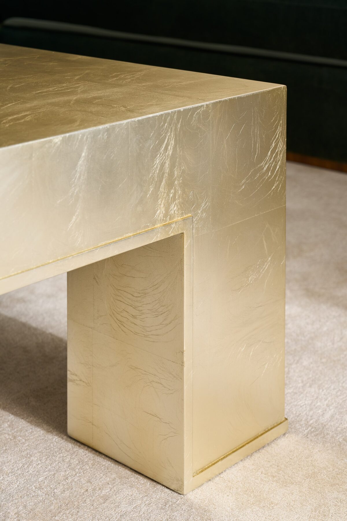 Rectangular Caracole table with a reflective top and modern, crisscross metal legs.